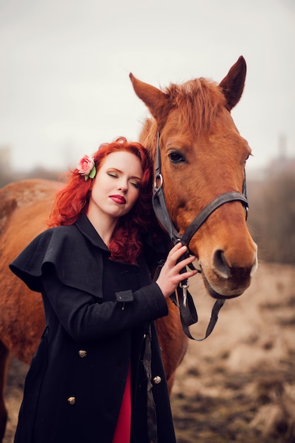 Jovem mulher e um cavalo.