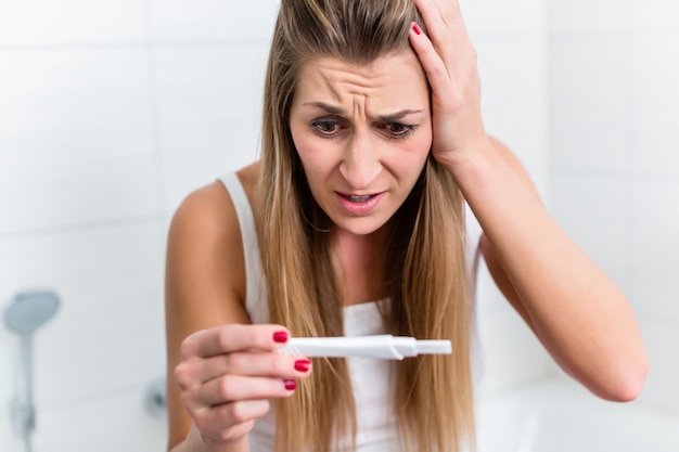 Jovem mulher em desespero sobre o resultado de sua gravidez tes