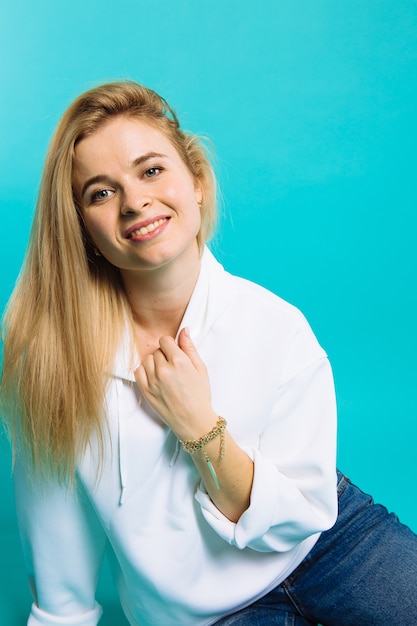 Jovem mulher em hoody branco sobre fundo azul. Bela menina