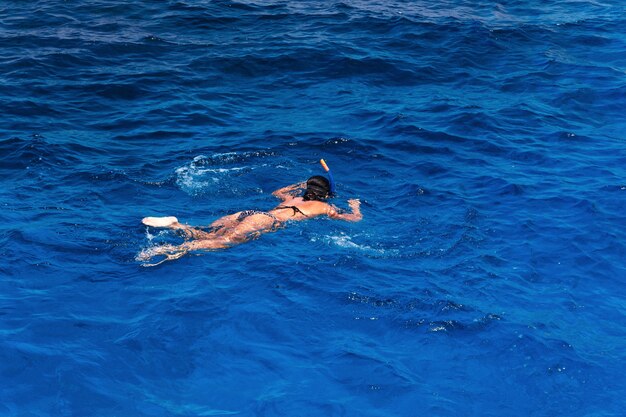 Jovem mulher em traje de banho snorkeling