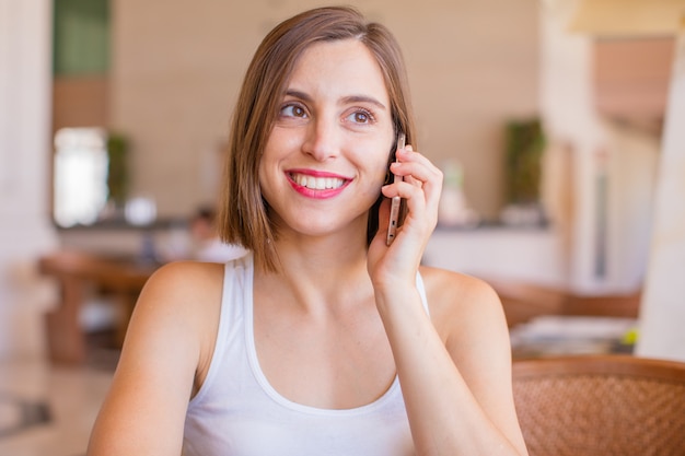 jovem mulher em um resort com um telefone celular