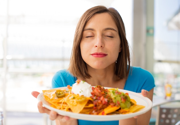 Foto jovem mulher em um restaurante com nachos