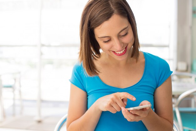 Foto jovem mulher em um restaurante com um telefone celular