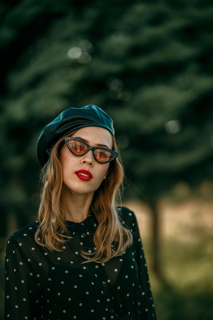 Jovem mulher em um vestido de bolinhas preto vintage posando fora