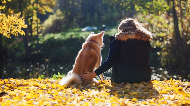 Jovem mulher em uma caminhada com seu cão raça Akita inu