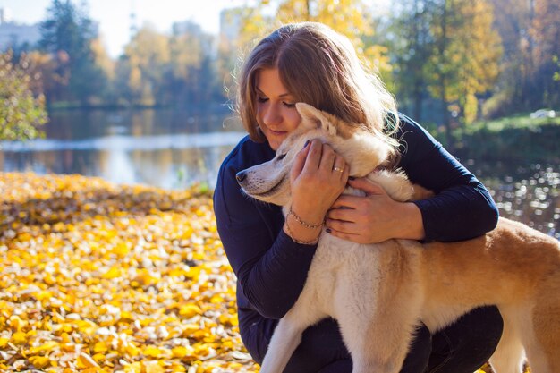 Jovem mulher em uma caminhada com seu cão raça Akita inu