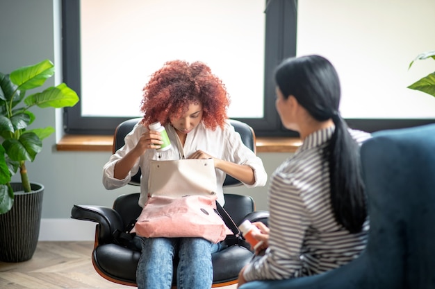 Jovem mulher encaracolada conversando com seu psicoterapeuta