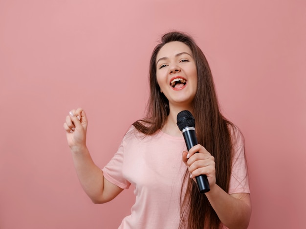 Jovem mulher engraçada com microfone na mão