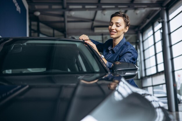 Jovem mulher escolhendo um carro no showroom de carros