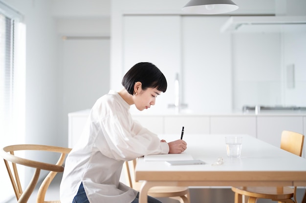 Jovem mulher escrevendo no caderno