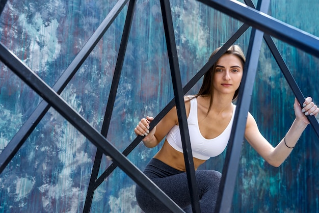 Jovem mulher esportiva posando em paisagem urbana