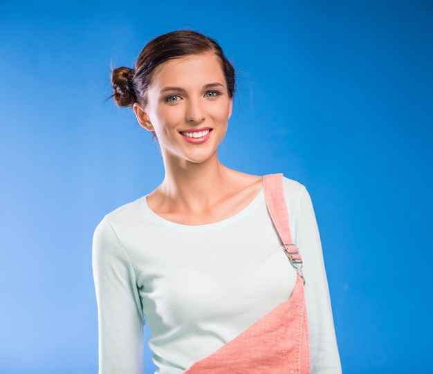 Jovem mulher está de pé e sorrindo.