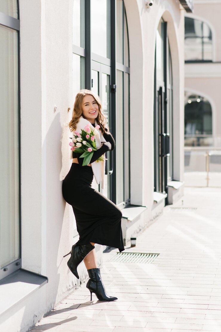Foto jovem mulher está distraída de sua rotina diária desfrutando da beleza das tulipas andando pela cidade