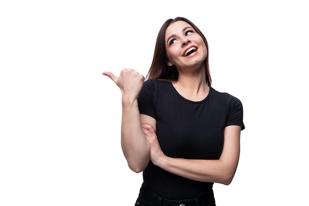 Jovem mulher europeia sorridente vestida com uma camiseta básica apontando com o dedo