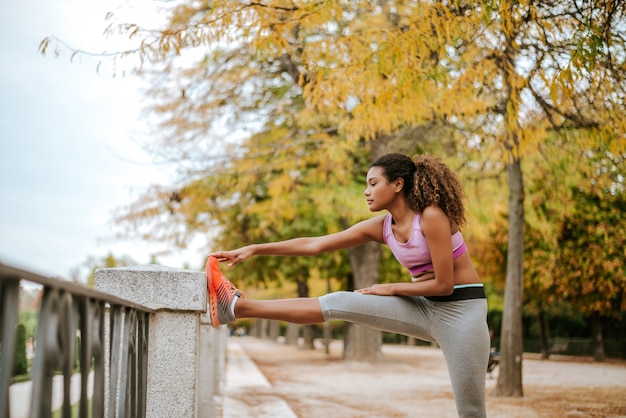 Jovem mulher exercitando no parque.