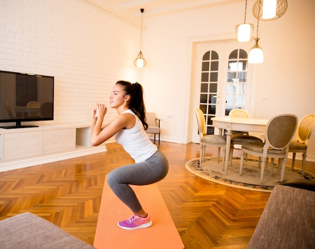 Jovem mulher exsercise no quarto em casa