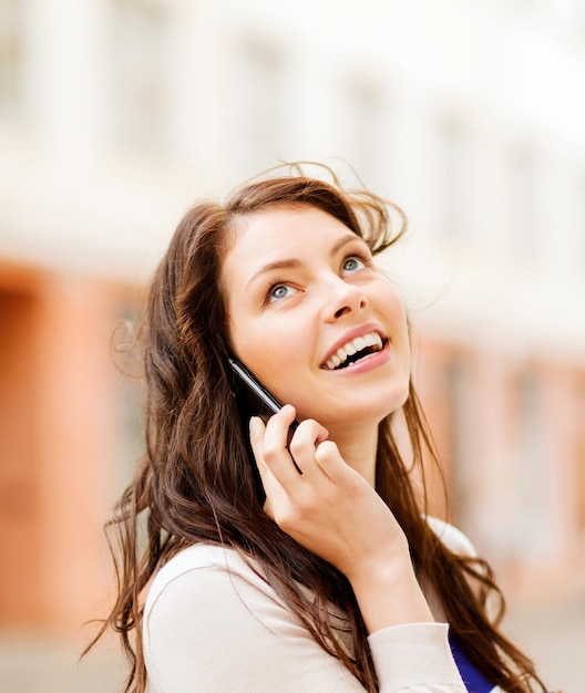 Jovem mulher falando ao telefone ao ar livre