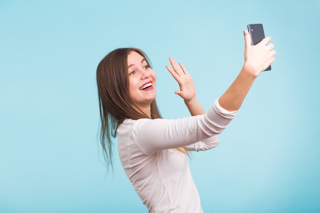 Jovem mulher falando com um amigo por meio de uma videochamada em um smartphone. Linda garota tendo um vídeo