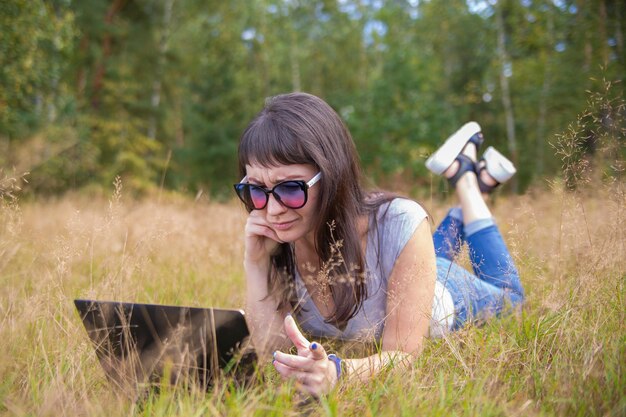 Jovem mulher falando emocionalmente ao telefone e olhando para um laptop freelancer trabalha em um