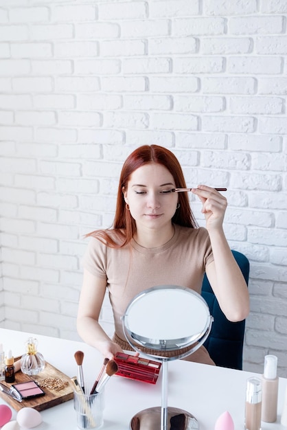 Jovem mulher fazendo as pazes em casa usando sombras