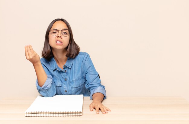 Jovem mulher fazendo gesto de dinheiro