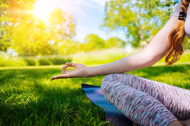 Jovem mulher fazendo ioga asana no parque, garota, exercícios de alongamento em posição de ioga, feliz e saudável