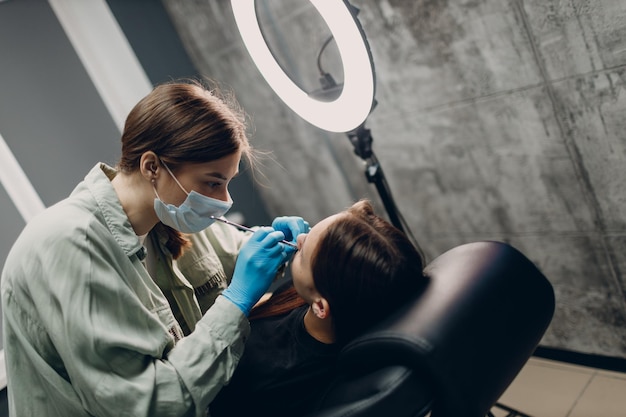 Jovem mulher fazendo piercing no salão de estúdio de beleza