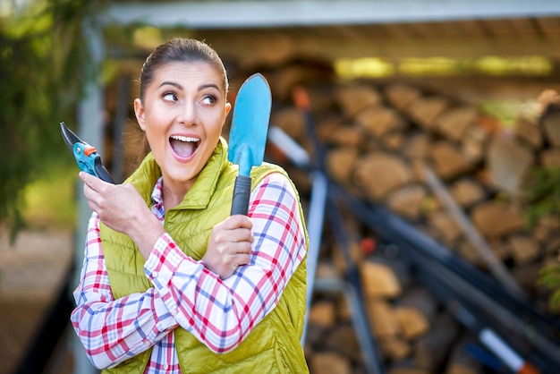 Jovem mulher feliz com ferramentas de jardim trabalhando