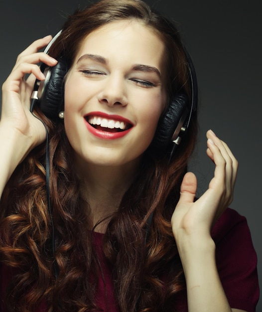 Jovem mulher feliz com fones de ouvido escutando música