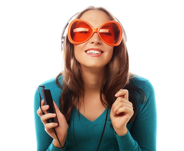 Jovem mulher feliz com fones de ouvido ouvindo música sobre fundo branco