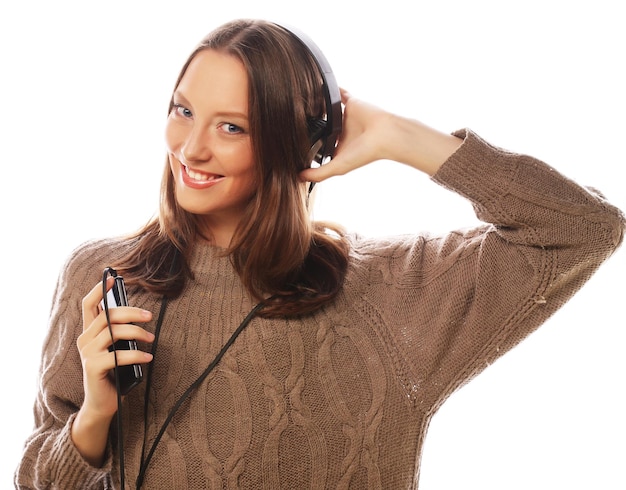 Jovem mulher feliz com fones de ouvido ouvindo música sobre fundo branco