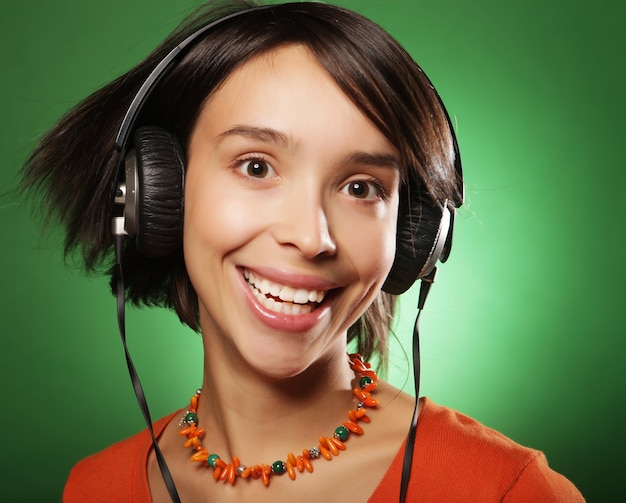 Jovem mulher feliz com fones de ouvido ouvindo música