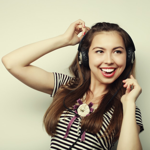 Jovem mulher feliz com fones de ouvido, ouvindo música