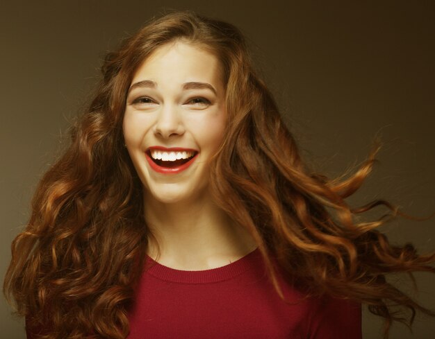 Jovem mulher feliz com o vento no cabelo. Tiro do estúdio.