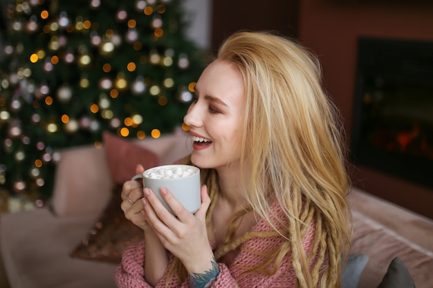 Jovem mulher feliz comemorando o natal em casa