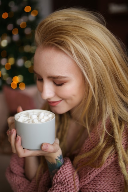 Jovem mulher feliz comemorando o natal em casa