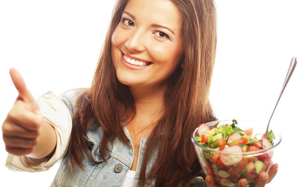 Foto jovem mulher feliz comendo salada