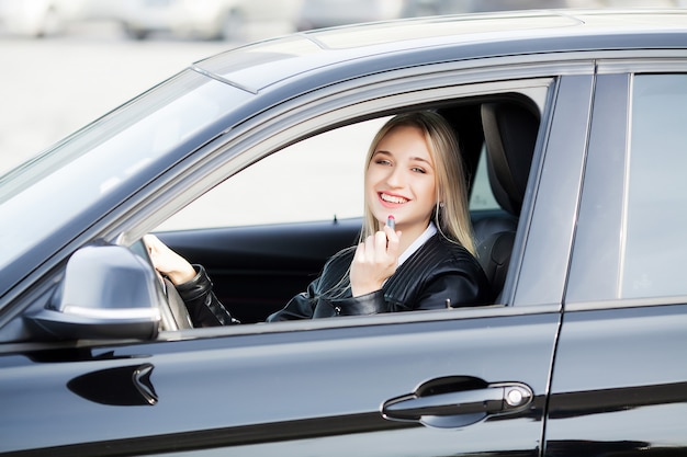 Jovem mulher feliz comprou carro moderno novo.