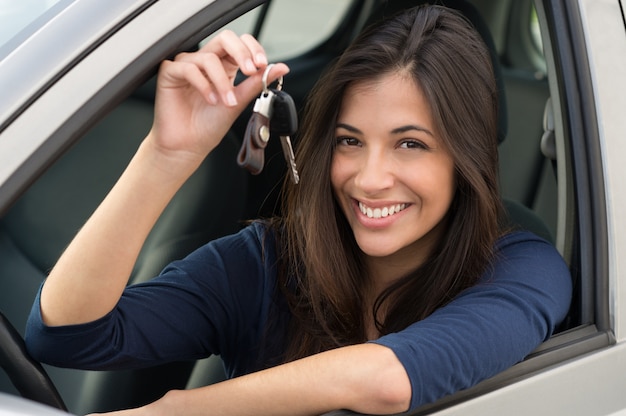 Jovem mulher feliz mostrando a chave do carro novo