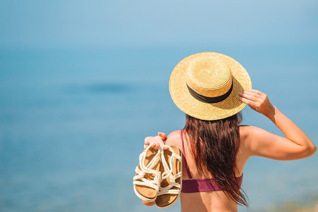 Jovem mulher feliz na praia com vista para a montanha