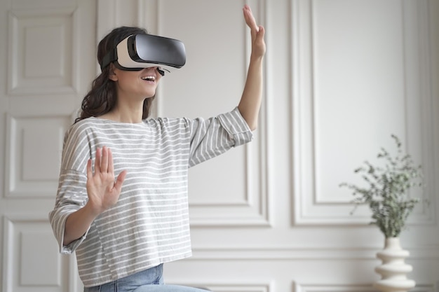 Jovem mulher feliz no fone de ouvido de realidade virtual desfrutando de uma experiência de compra divertida no mundo aumentado