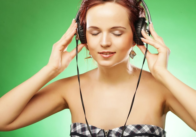 Jovem mulher feliz ouvindo música com headhones