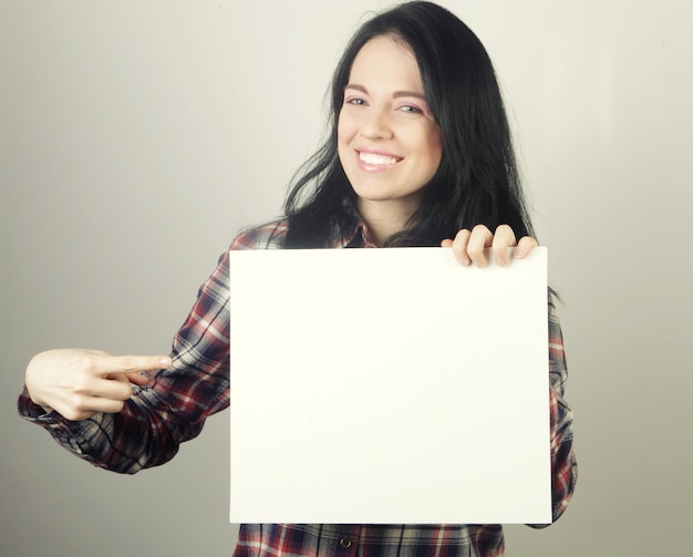 Jovem mulher feliz segurando cartaz em branco