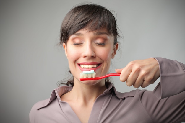 Jovem mulher feliz segurando uma escova de dentes