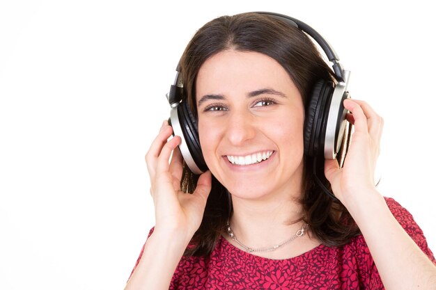 Jovem mulher feliz sorridente com fones de ouvido ouve cantar música cantando ao lado do espaço da cópia