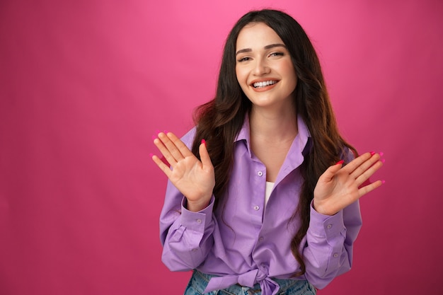 Jovem mulher feliz sorrindo sobre fundo rosa