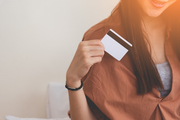 Jovem mulher feliz usando cartão de crédito