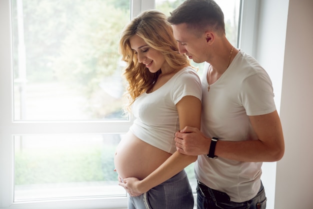 Jovem mulher grávida e o marido.