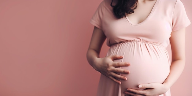 Jovem mulher grávida em fundo rosa