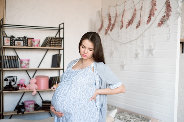 Foto jovem mulher grávida se sentindo mal em casa.